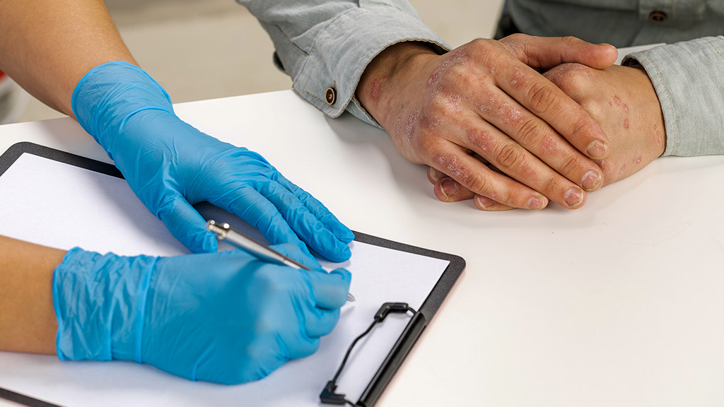 gloved dermatologist examines the skin of a sick patient and records observations