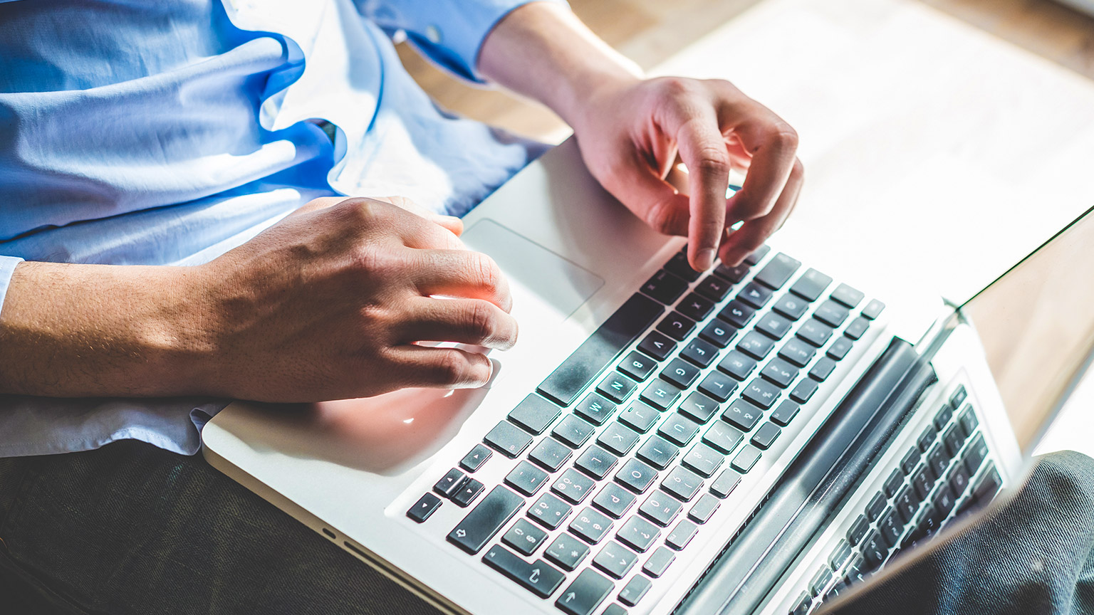 A person typing on a laptop