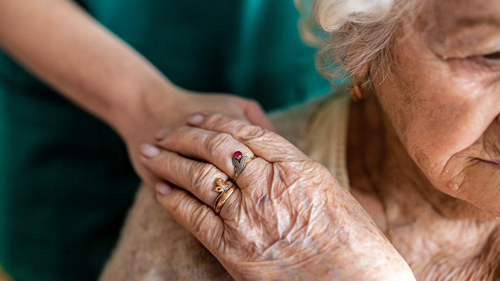 Cropped shot of a senior woman holding hands with a nurse