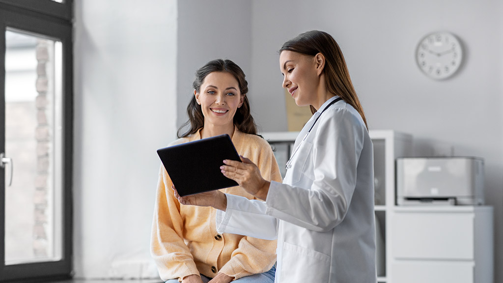 doctor holding a tablet talking to a patient at hospital