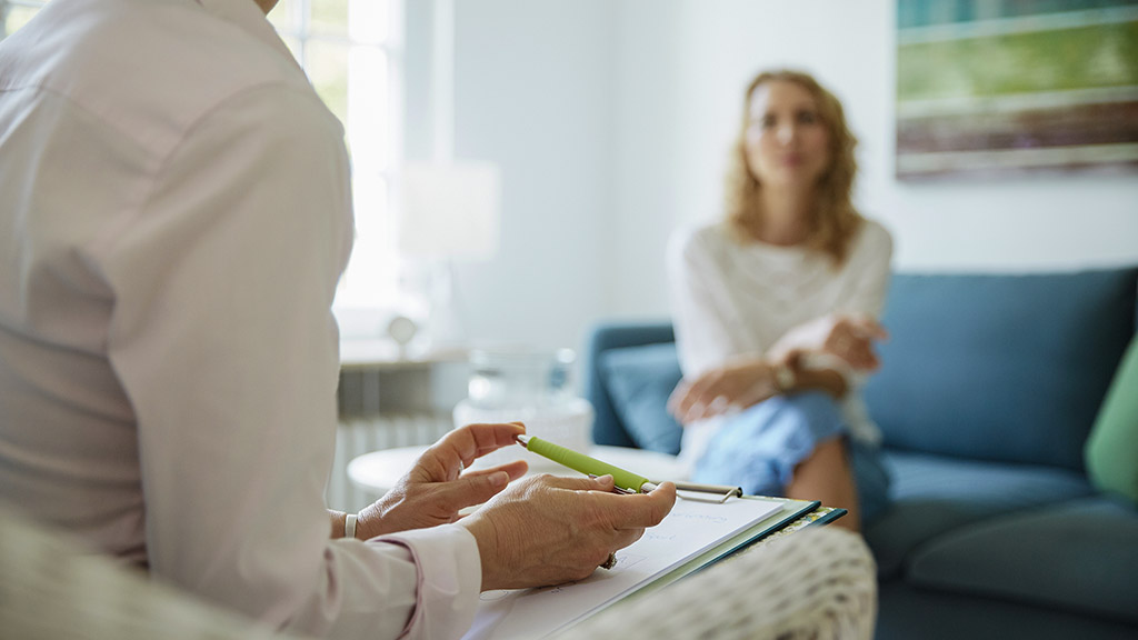 Counseling or therapy session with psychologist or doctor and client in office room