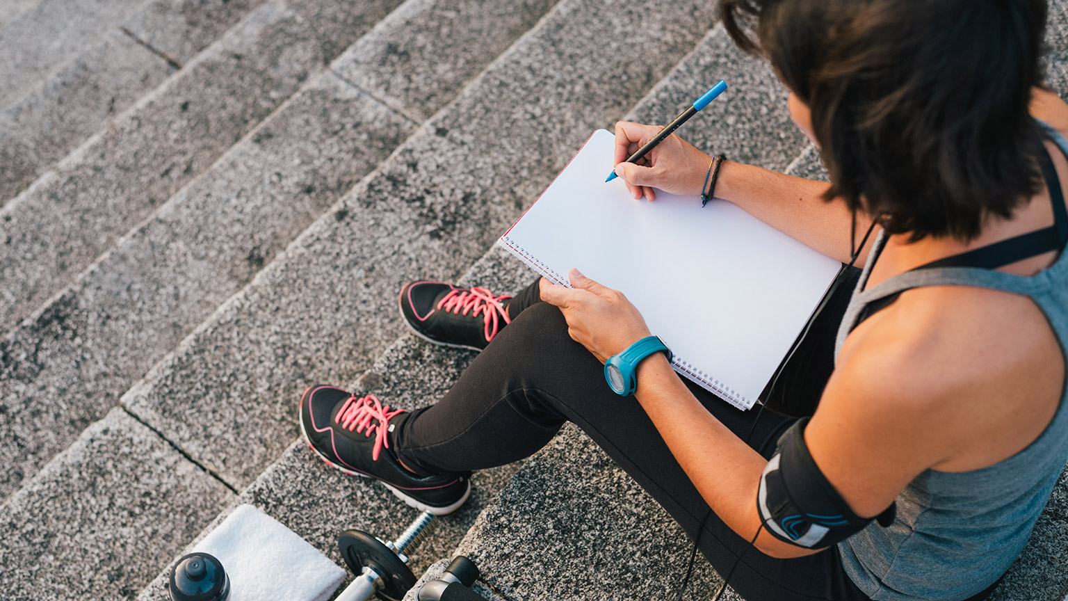 A trainer writing notes on a clipboard