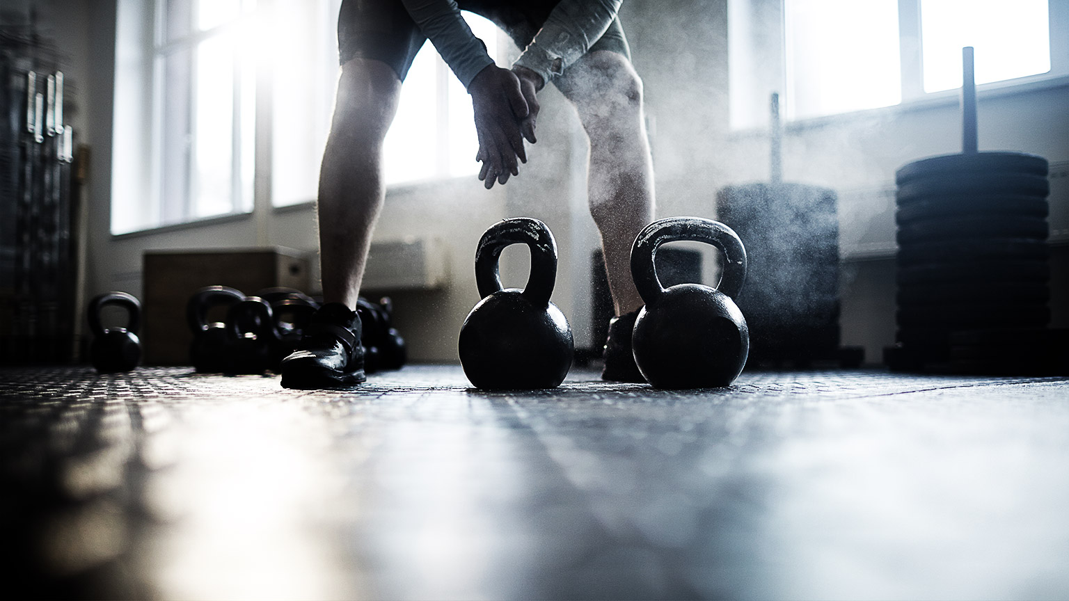 Dumbbells and weights for sports are on the rack and on the floor in the gym.