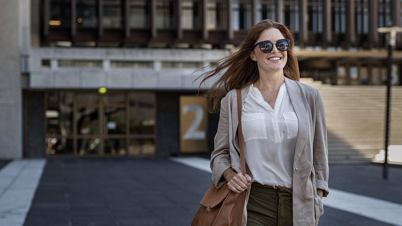 A person walking away happily from a building