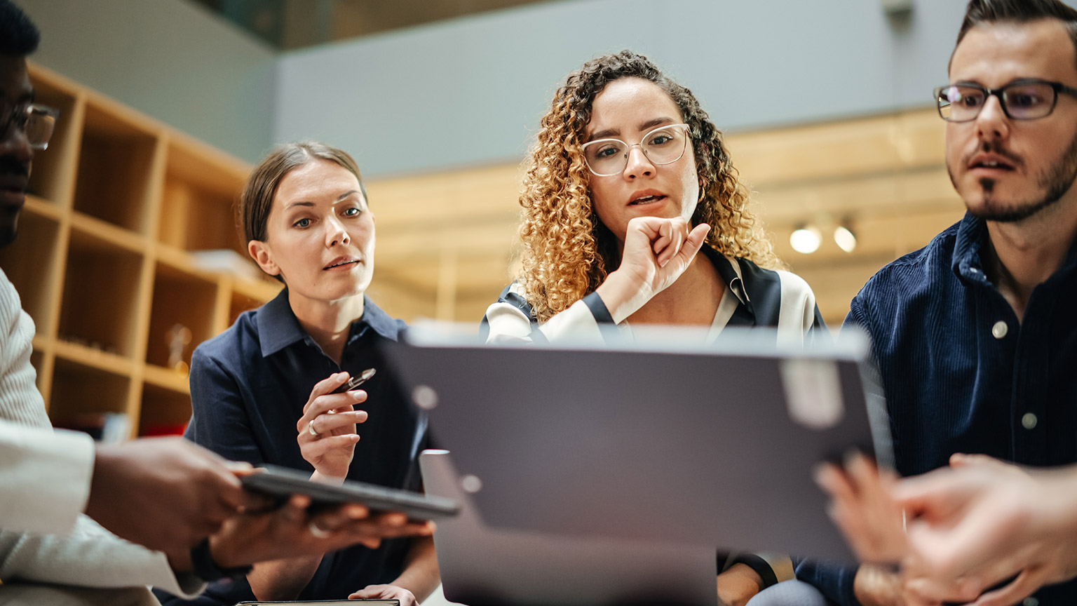 A group of coworkers discussing a project in an office