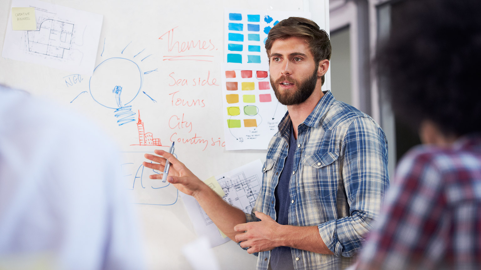 A designer standing in front of a whiteboard