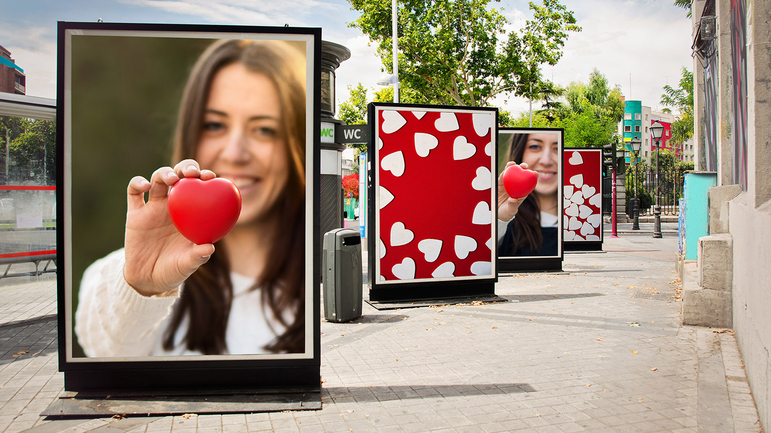 An love-heart ad campaign running on a street showing a woman holding a heart.