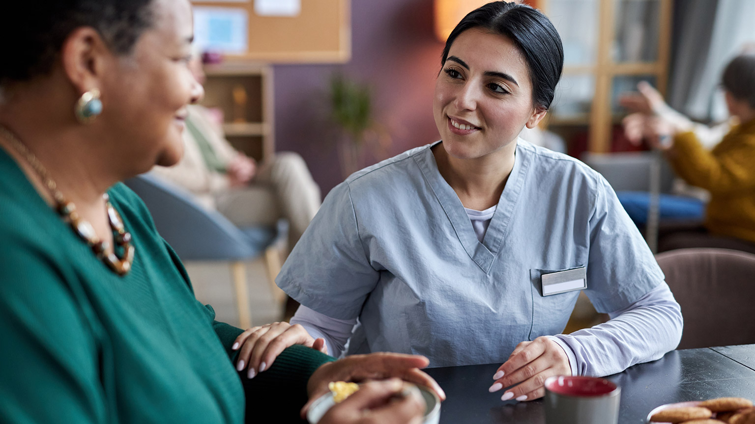 A carer and client talking in a care facility