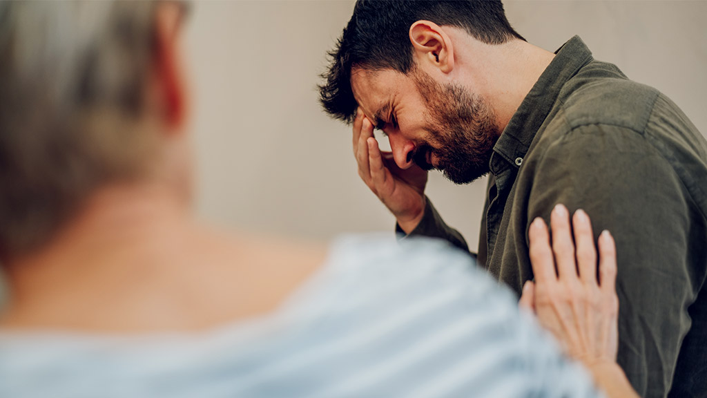 sad young man on therapy meeting discussing addiction and mental health problems