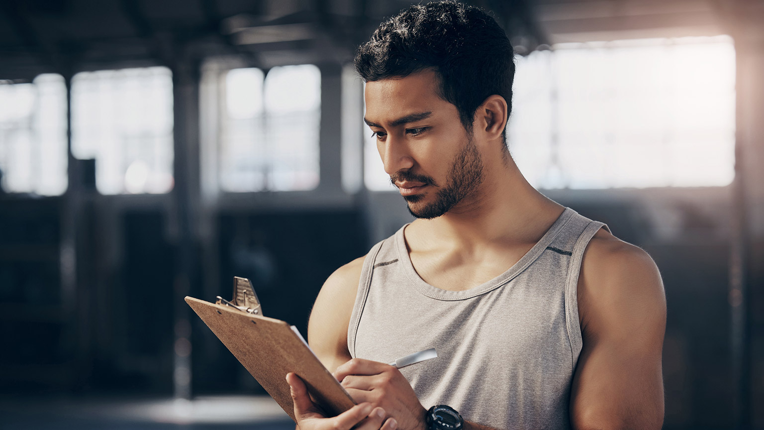 A trainer writing notes on a clipboard