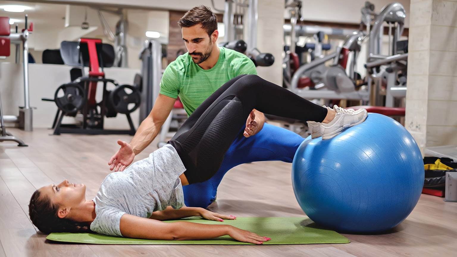 A trainer and client in a gym