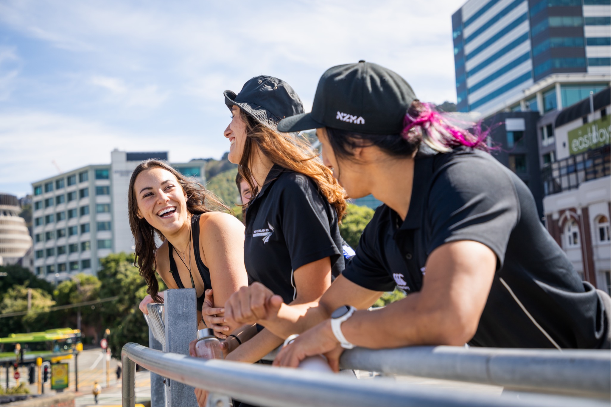 NZMA students are outside, laughing in front of a city background.