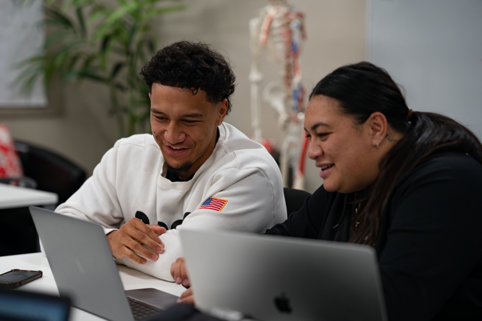 Two students discussing a project in a classroom