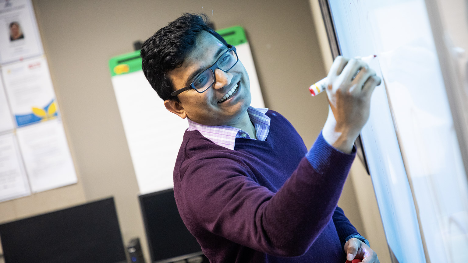 A lecturer writing on a board