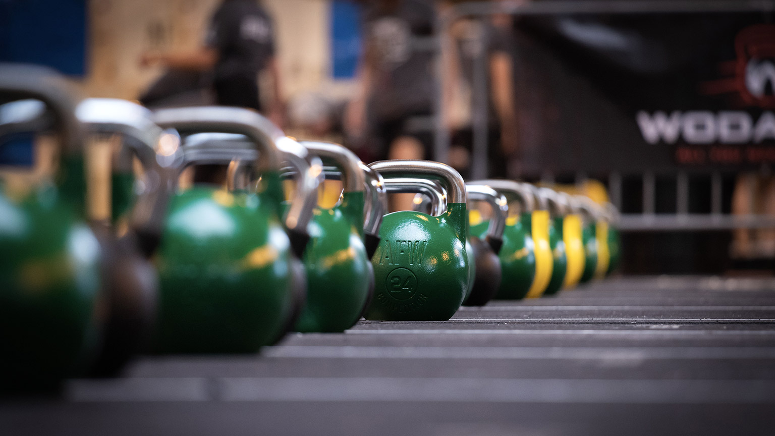 A line of kettle bells on the floor of a gym