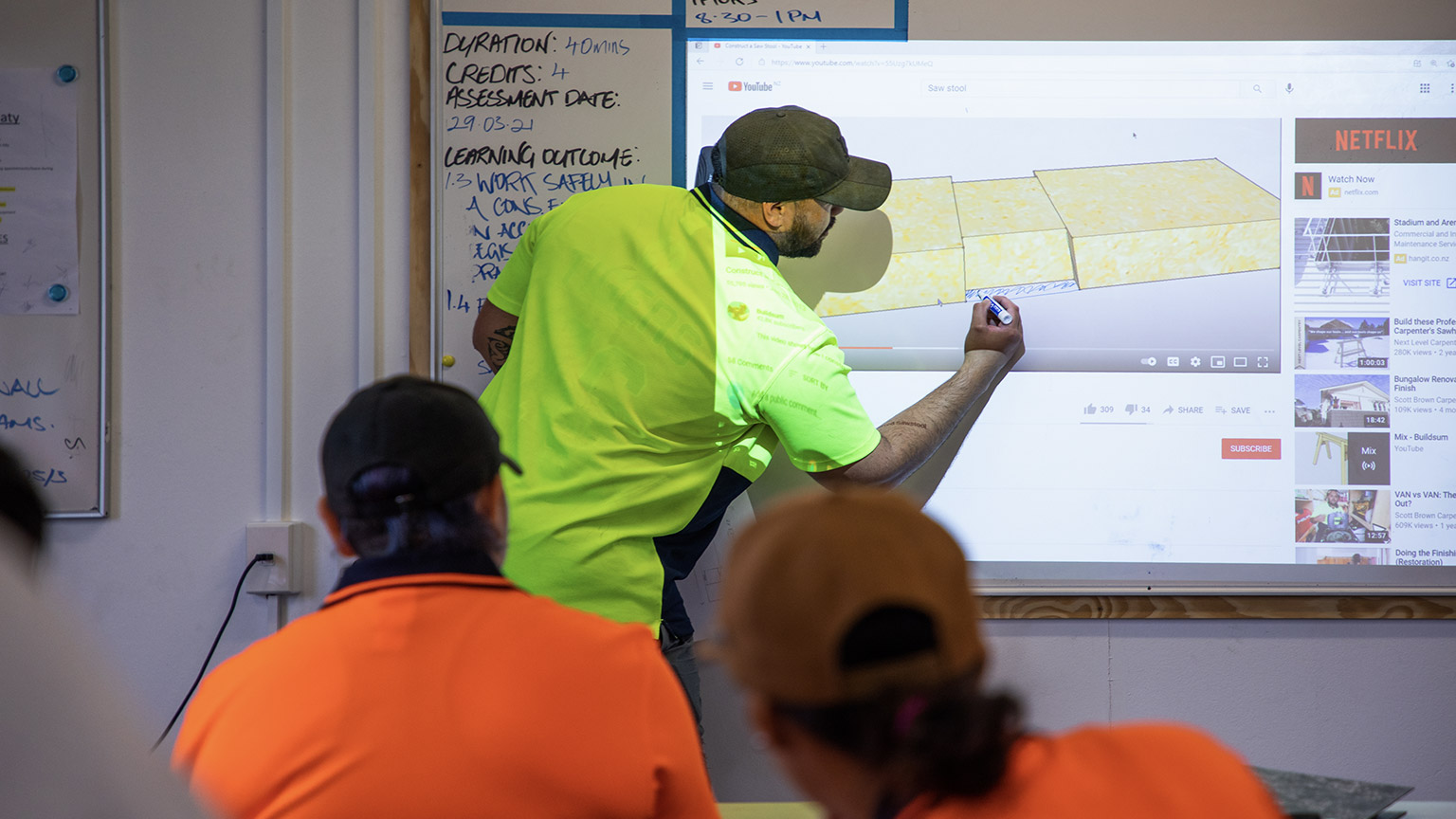 An instructor writing notes on the board for students