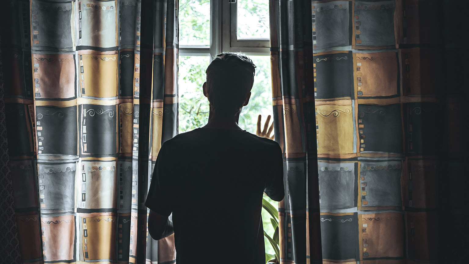 silhouette of a man looking out of the window