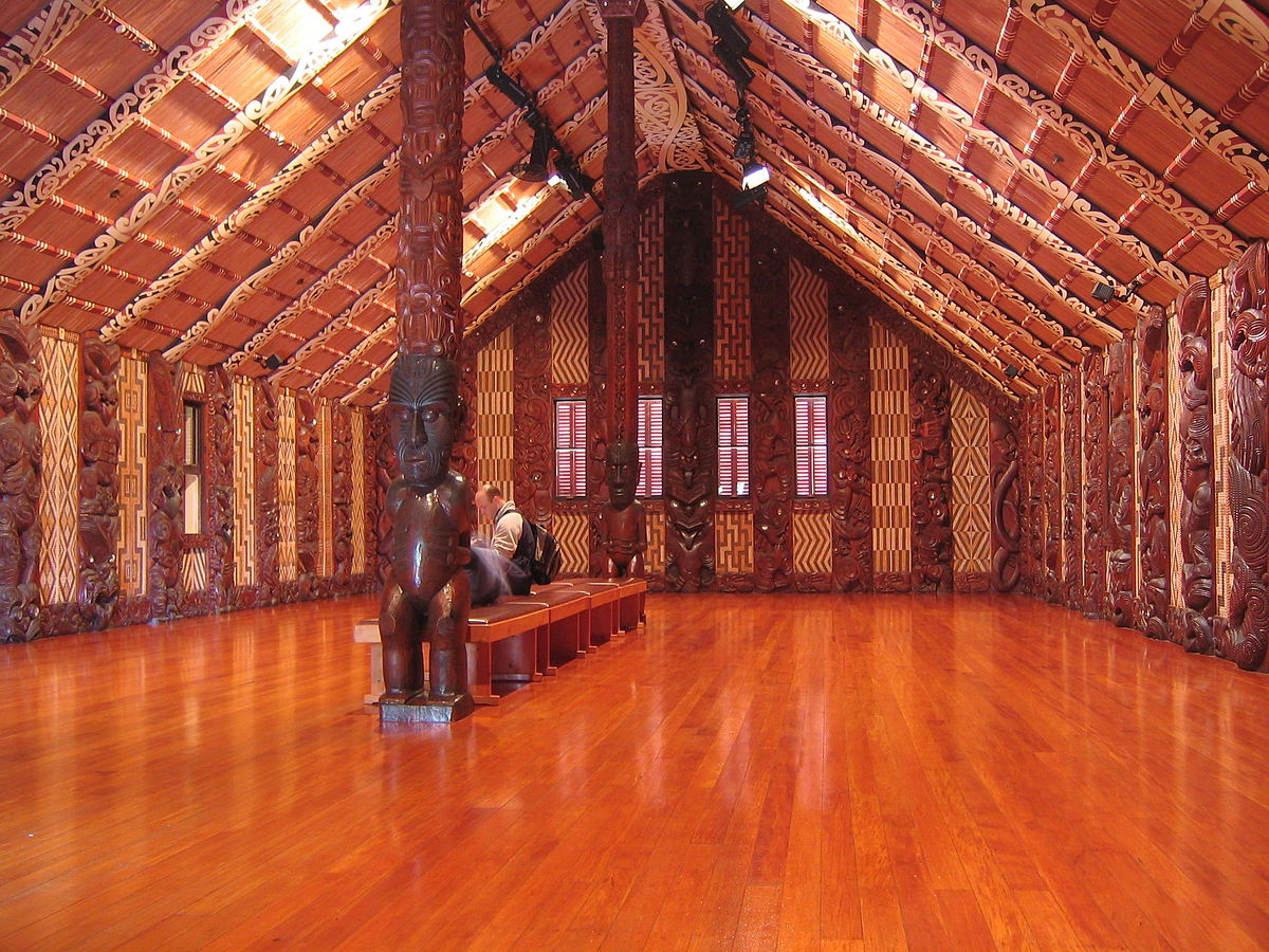 Visitors take a rest at inside the Wharenui meeting house in Waitangi, NZ.