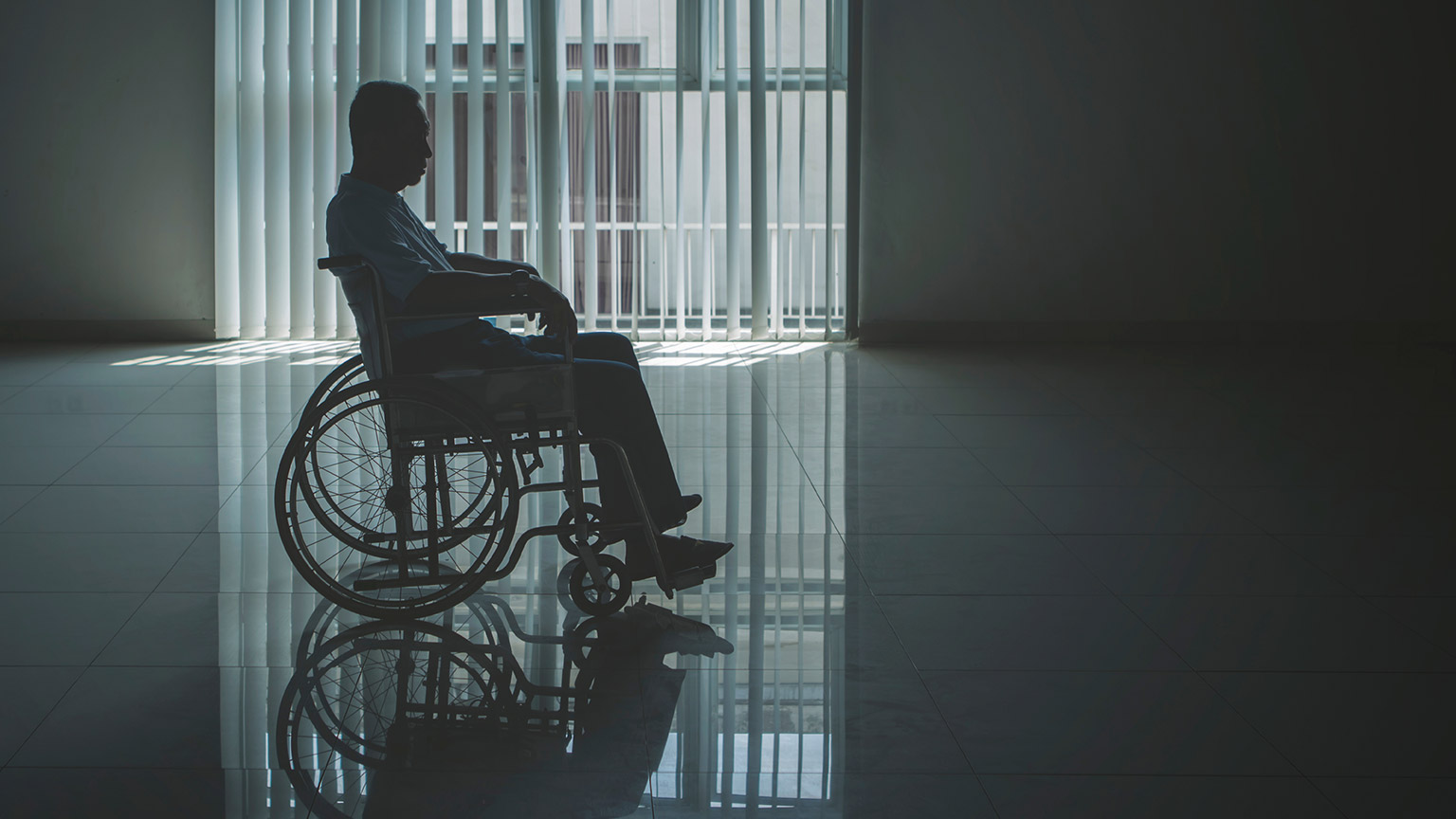 A wheelchair bound person in a dimly lit room