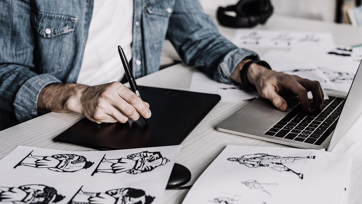 artist sitting at a desk creating animation on computer