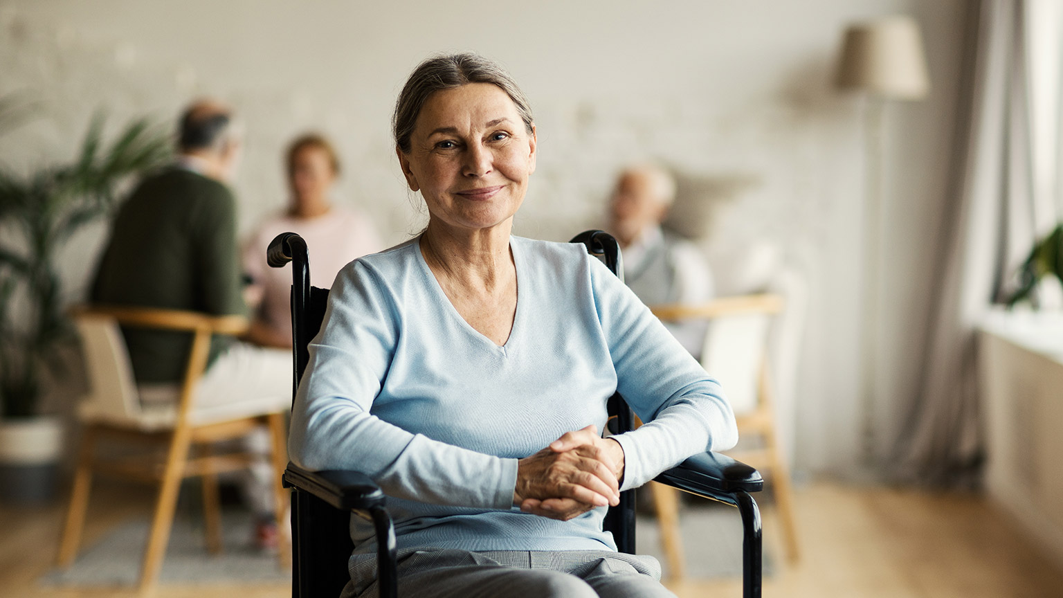 An elderly perosn in a wheelchair in an aged care facility