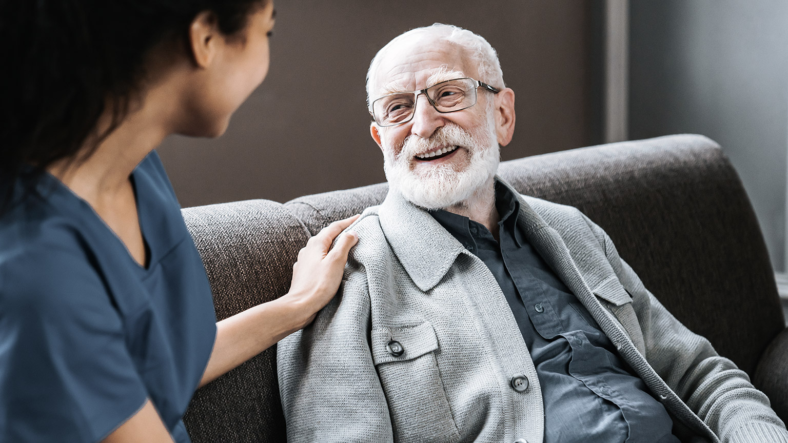 Caregiver talking with happy senior