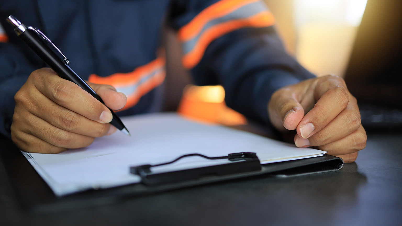 A supervisor writing notes on a form