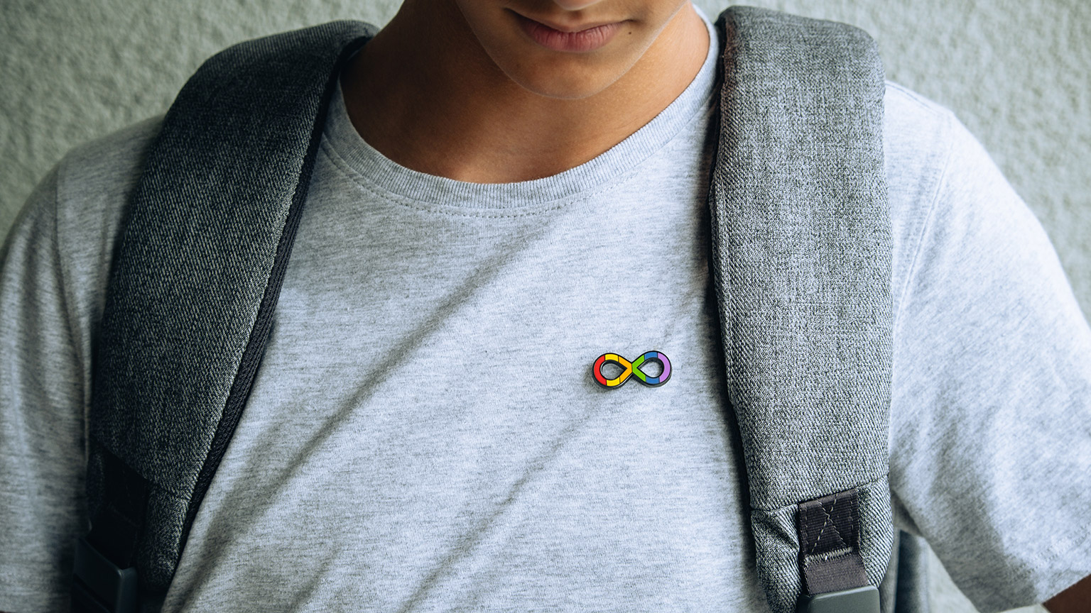 A young person wearing a badge signifying neurodiversity