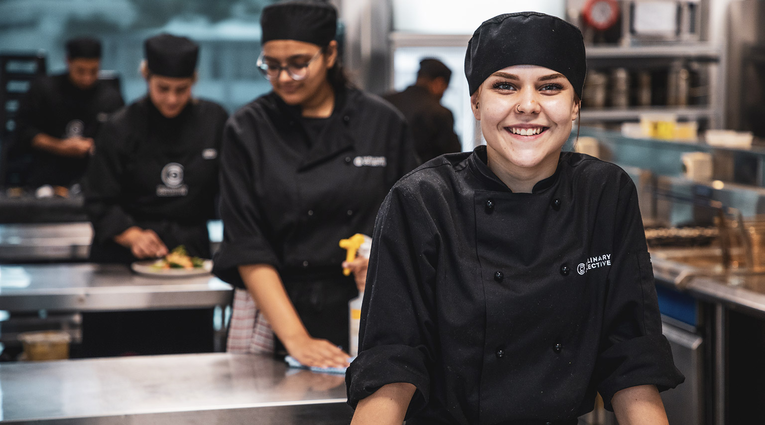 A smiling student in a kitchen