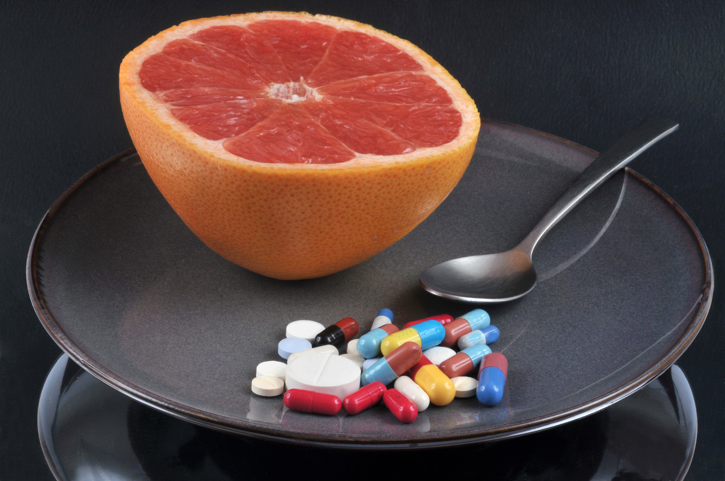 Grapefruit on a plate with medication next to it