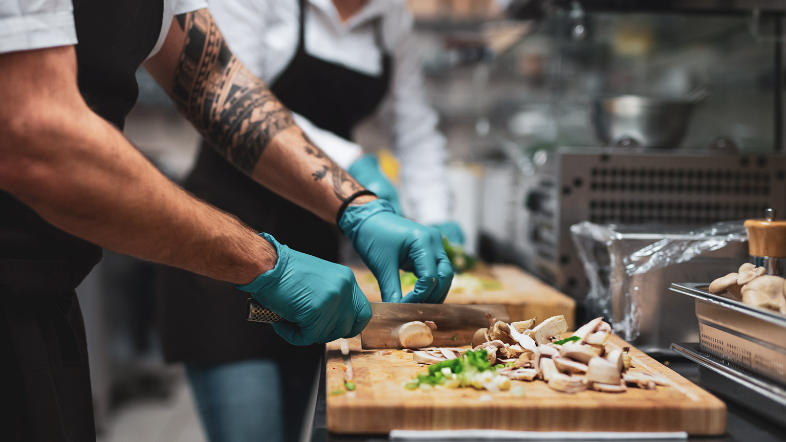 A chef cutting veggies on a cutting board