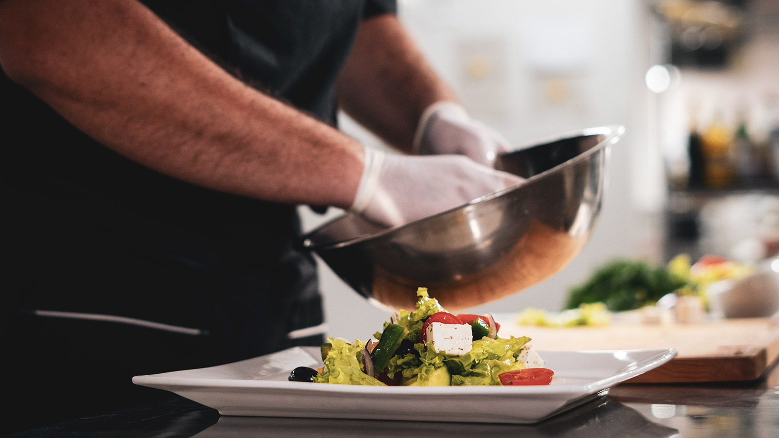 A chef plating up while wearing gloves