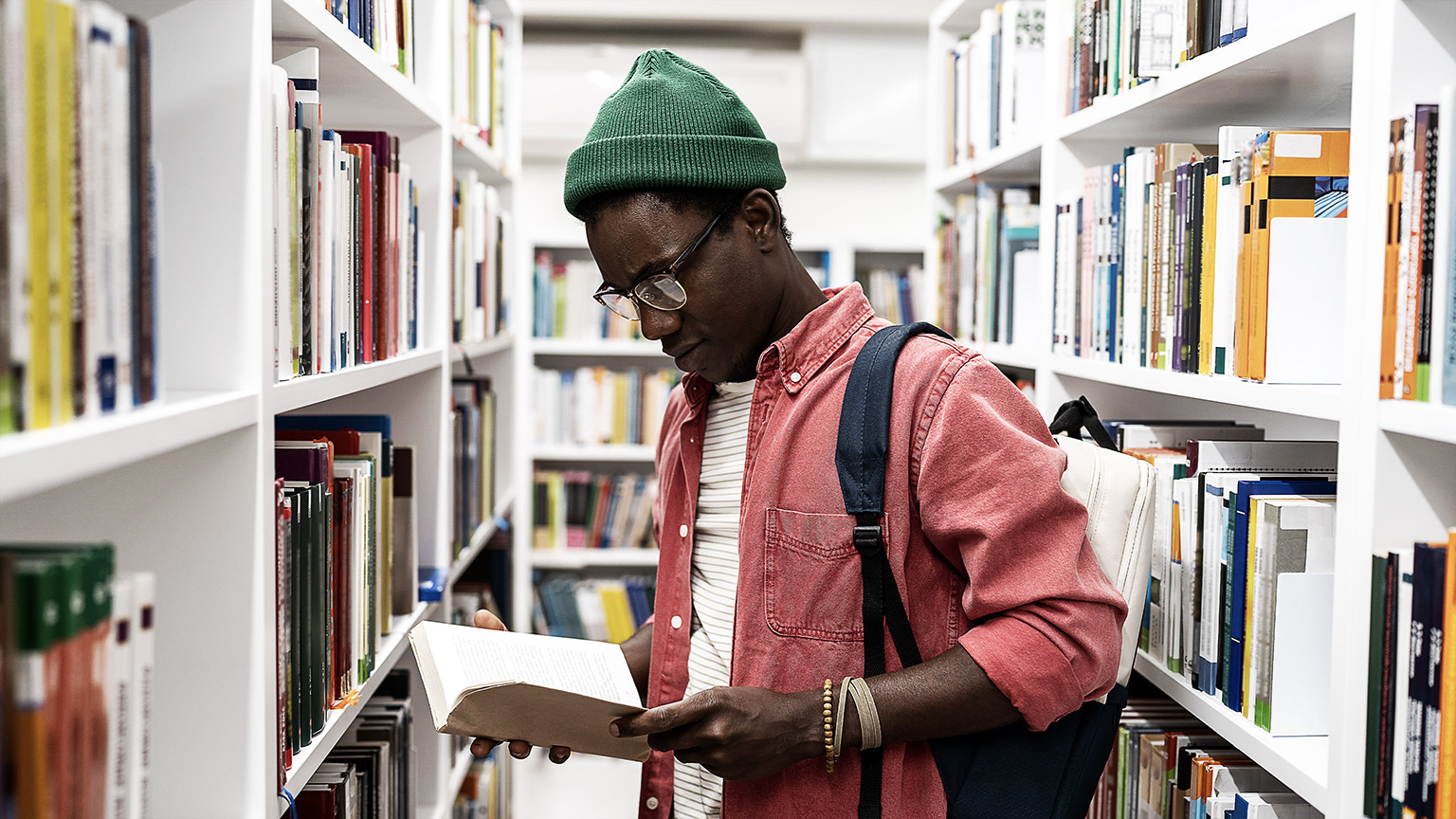 student choosing research textbooks in university library