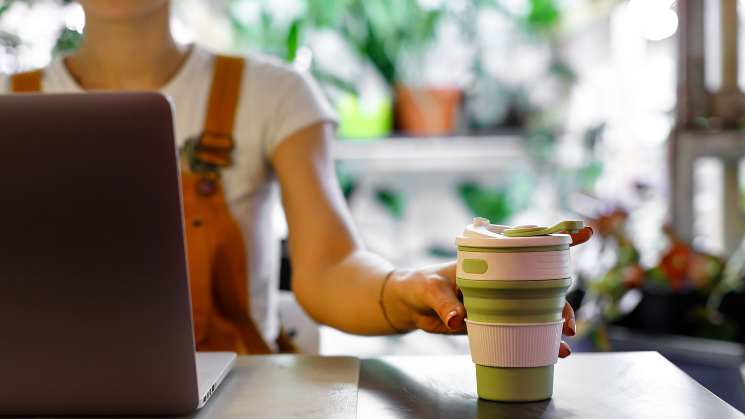 A person using a reusable coffee cup