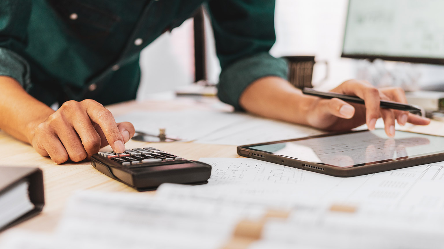 A person looking at a plan and using a calculator