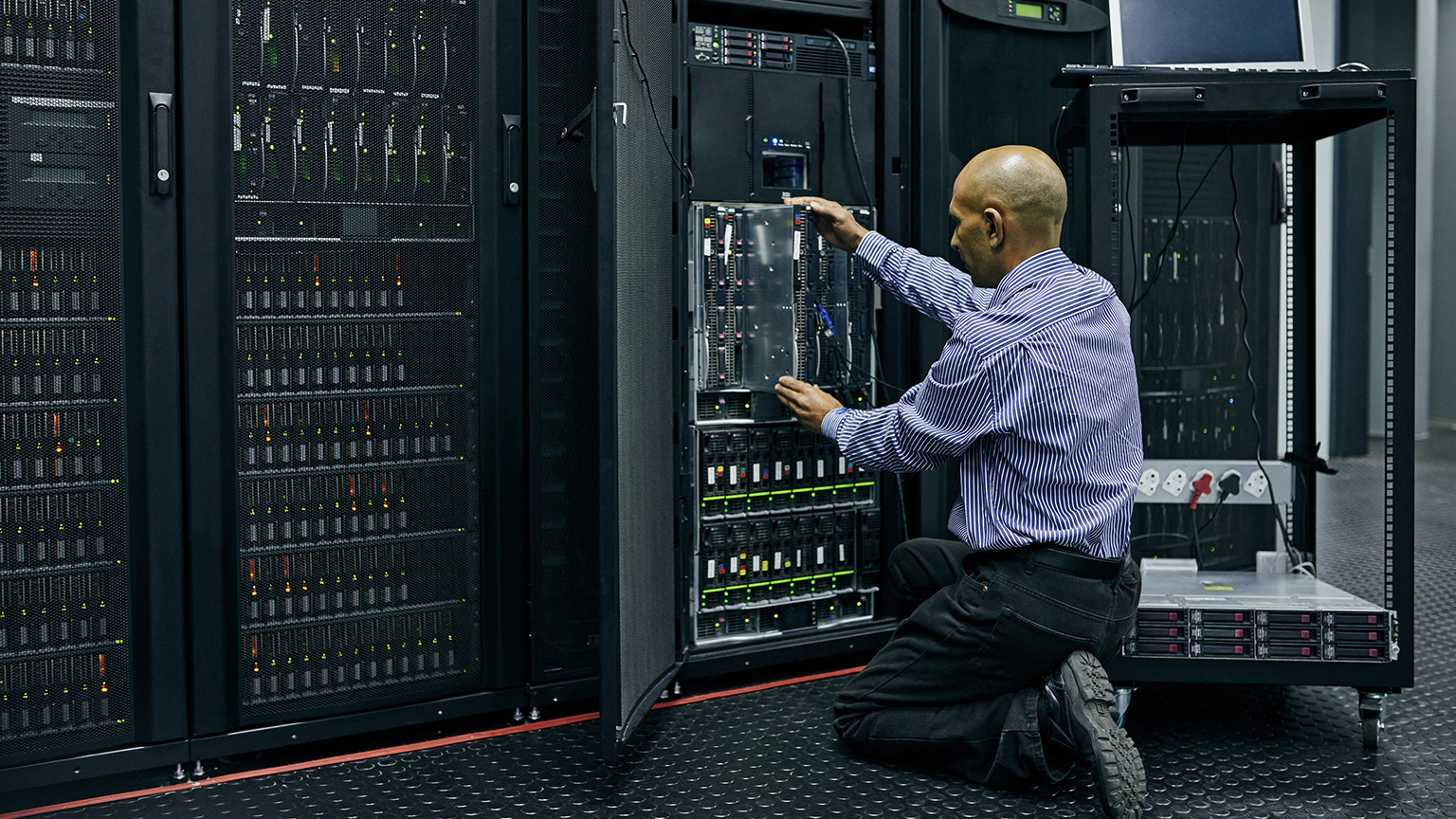 man engineer in a server room for cybersecurity maintenance on storage hardware