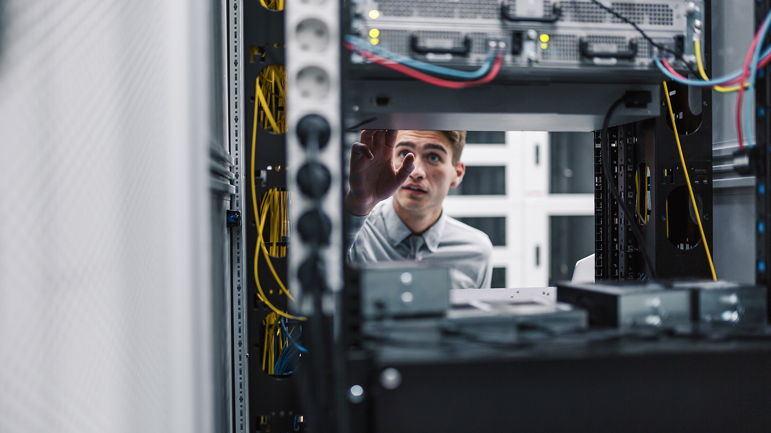 man with laptop working in data center