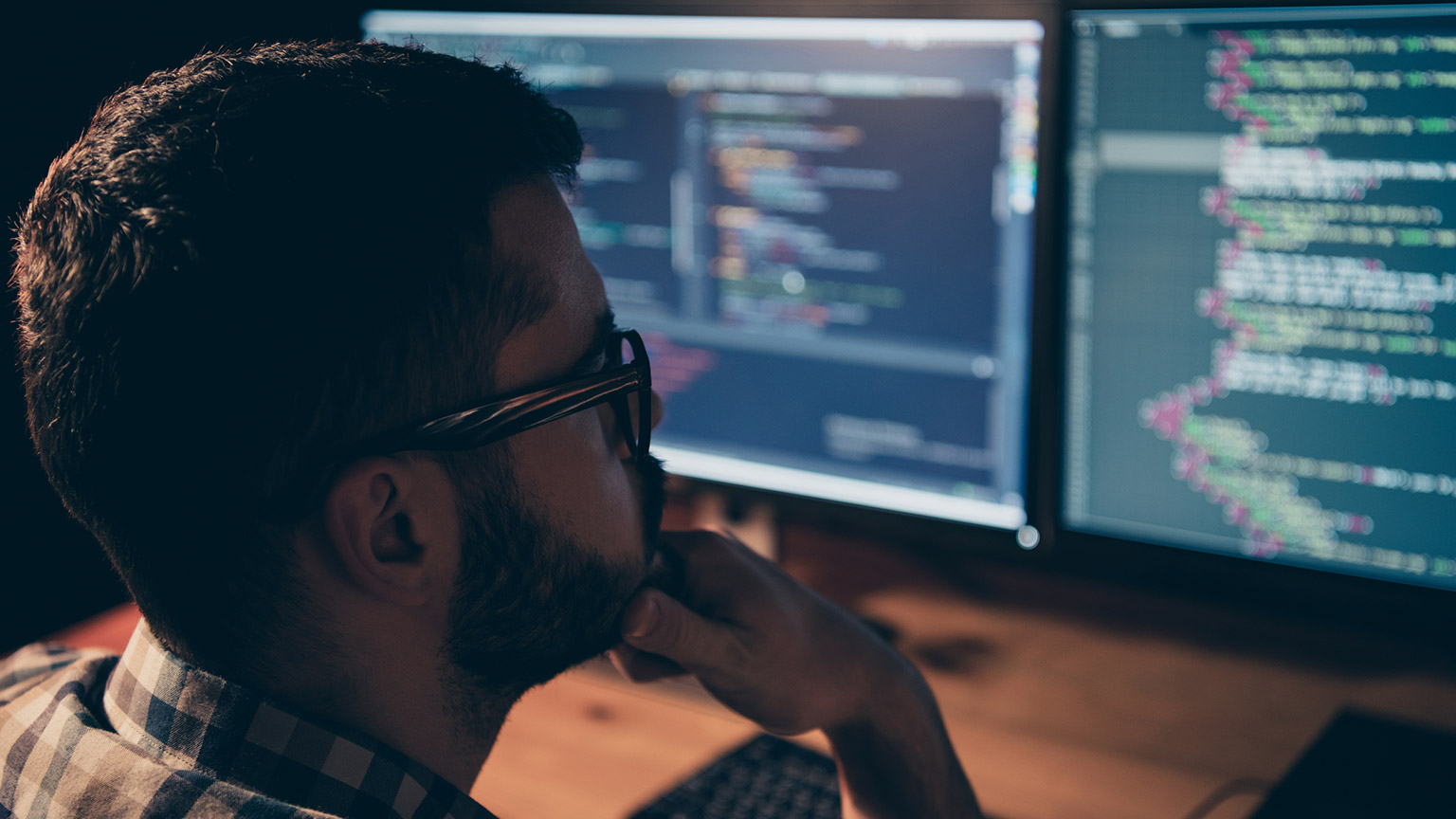 A programmer looking at code on a screen