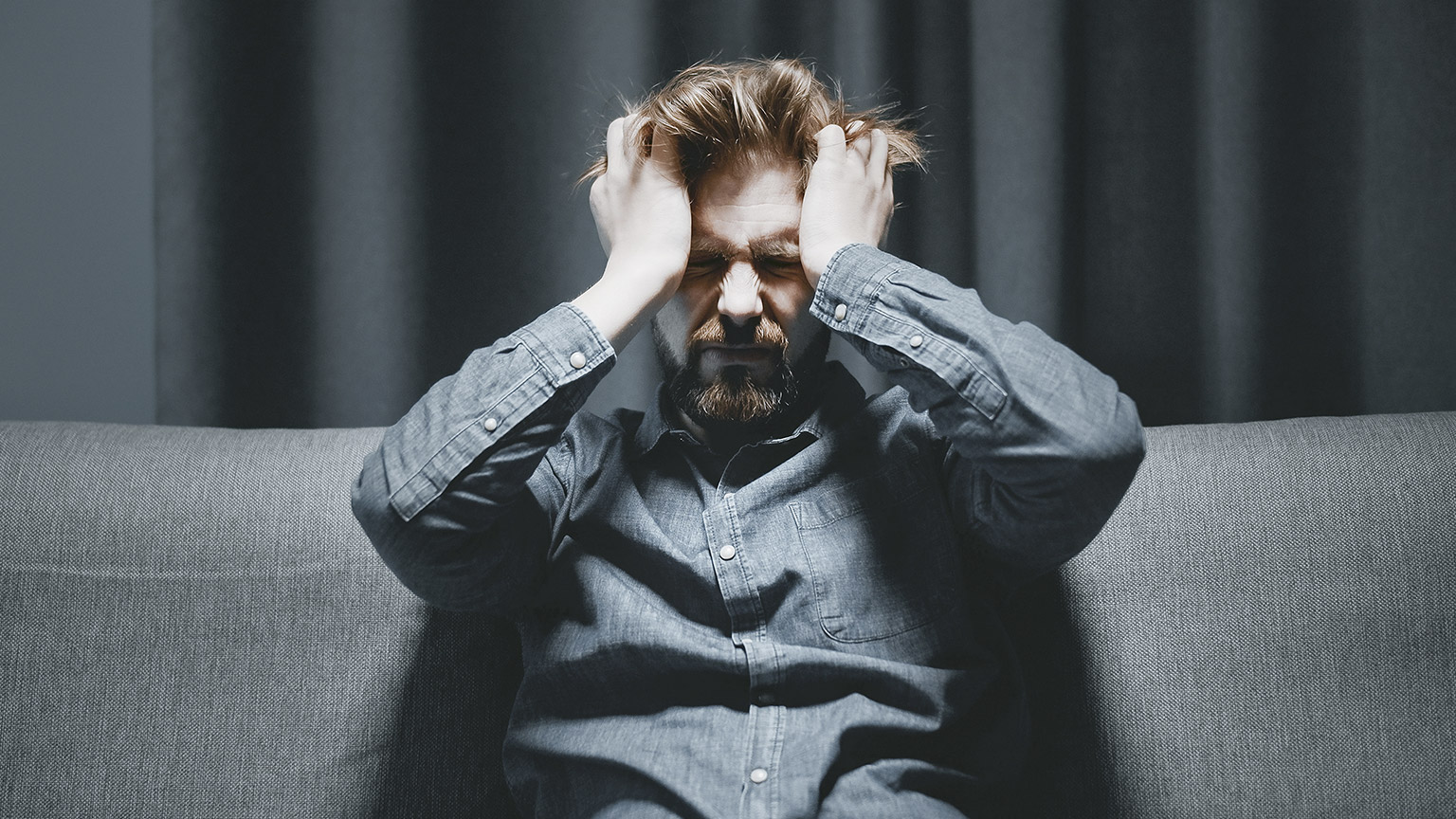 Depressed man squeezing his head