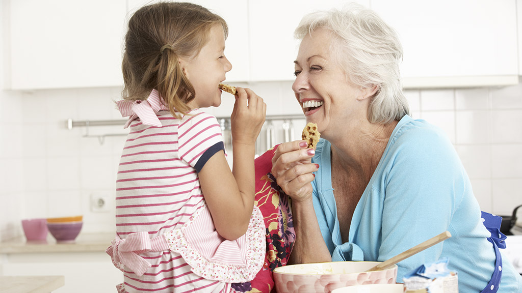 Grandmother And Granddaughter Baking In Kitchen