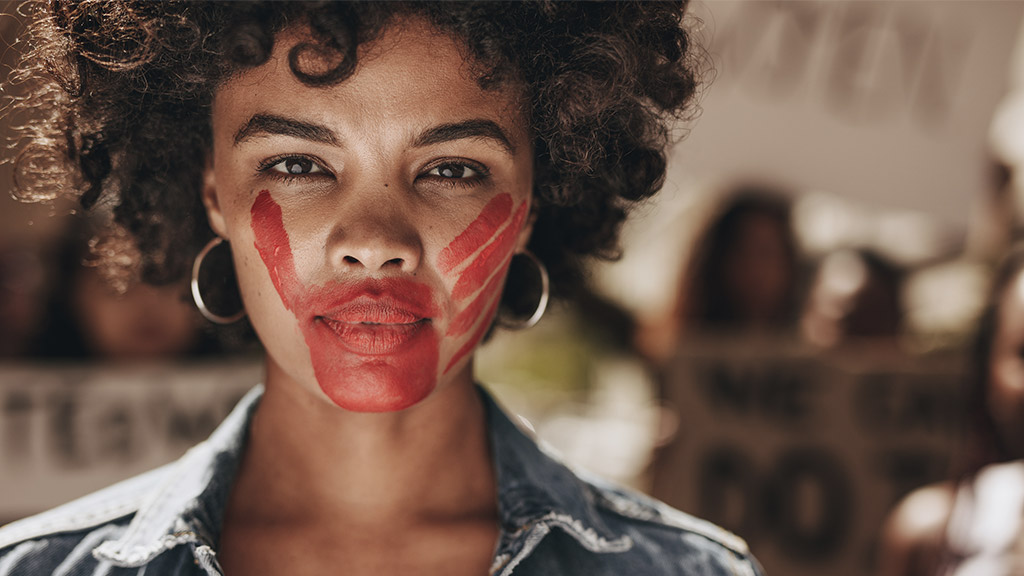 Female activist with a hand print on her mouth, demonstrating violence on women