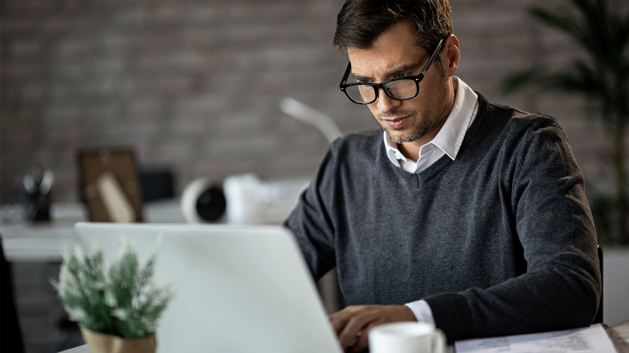  adult businessman working on a computer at his office desk.