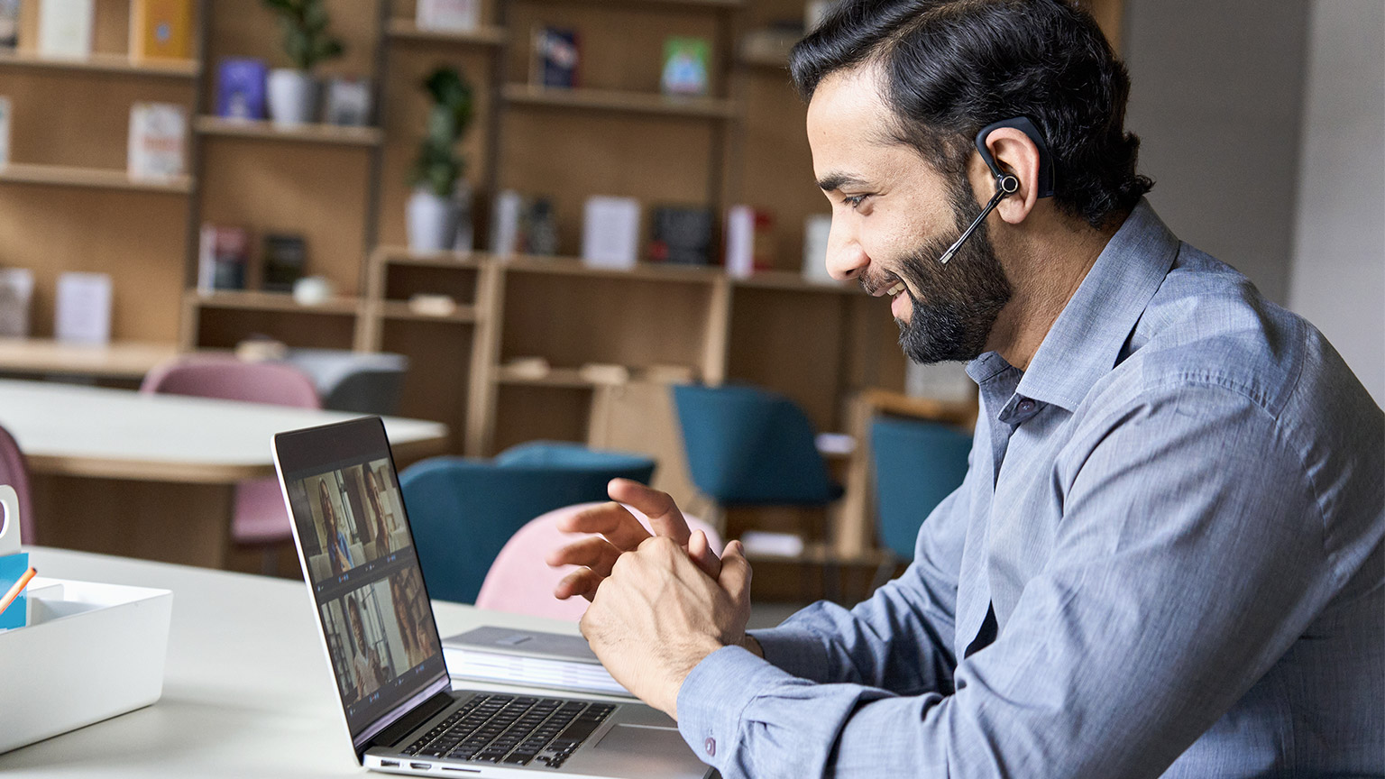 Latin indian smiling businessman wearing headset having virtual team meeting group call chatting with diverse people in customer support.