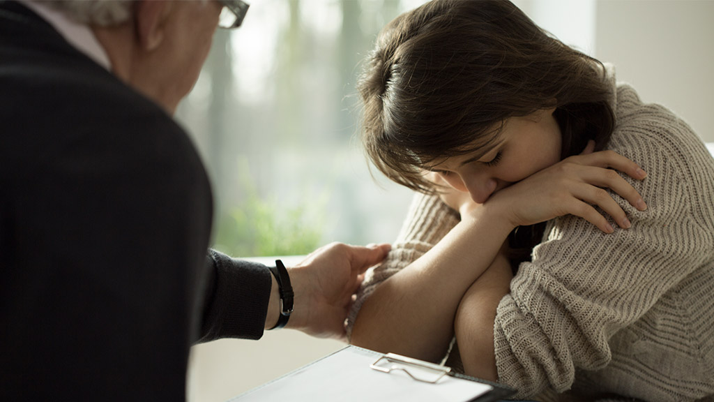 Close-up of psychologist comforting his depressed patient