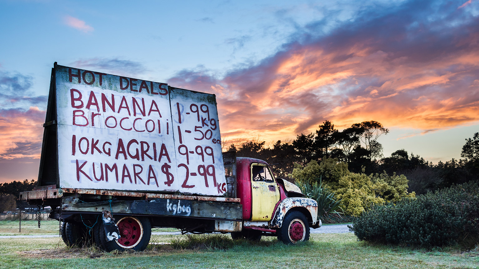 An old truck by the road advertising fruit and veggies