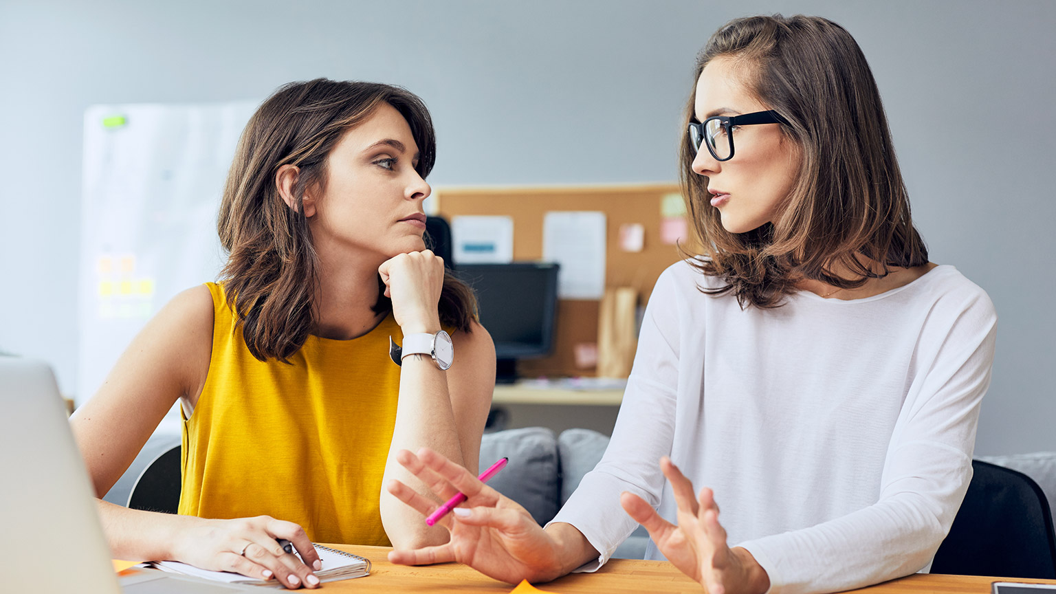 2 coworkers talking seriously in an office