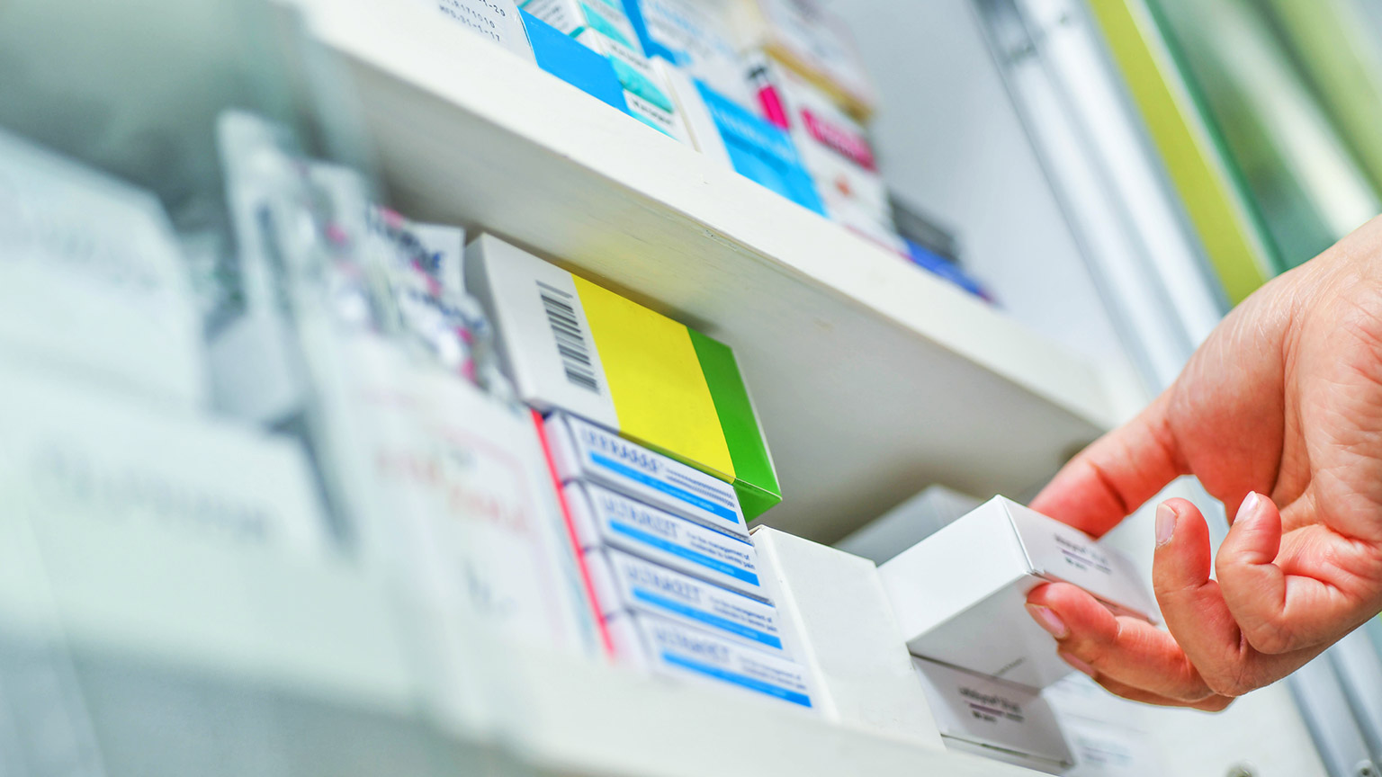 A pharmacist collecting medication off a shelf