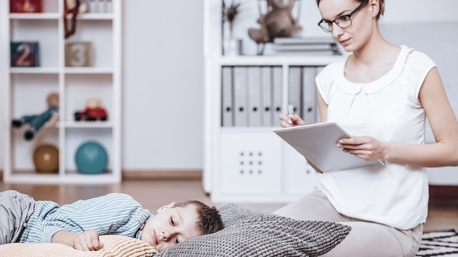 Mother taking notes with sleeping child beside her