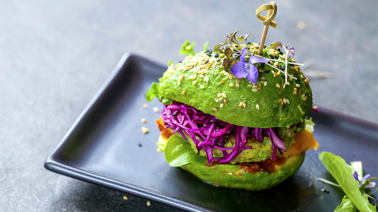 Avocado sandwich with green vegan burger, roast yellow pepper and pickled red cabbage