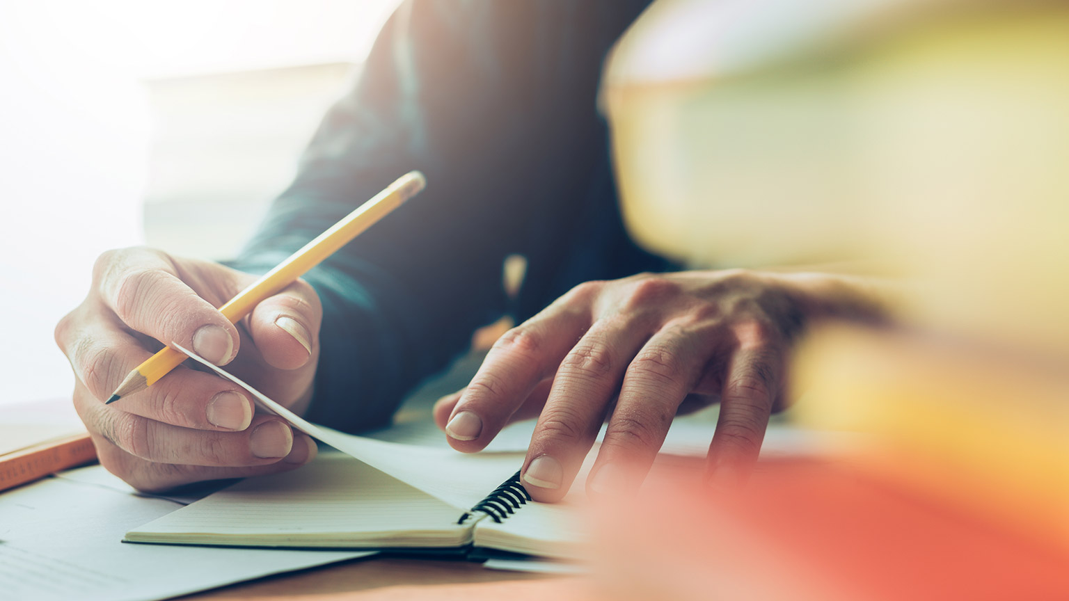 Close view of a person writing on a notepad